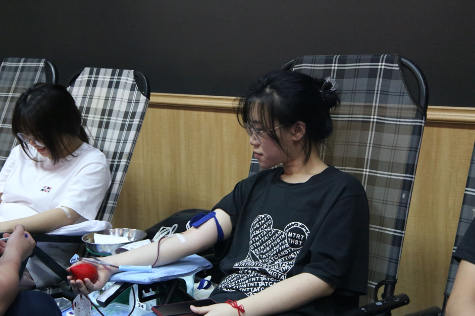 A person sitting in a chair with a blood donationDescription automatically generated